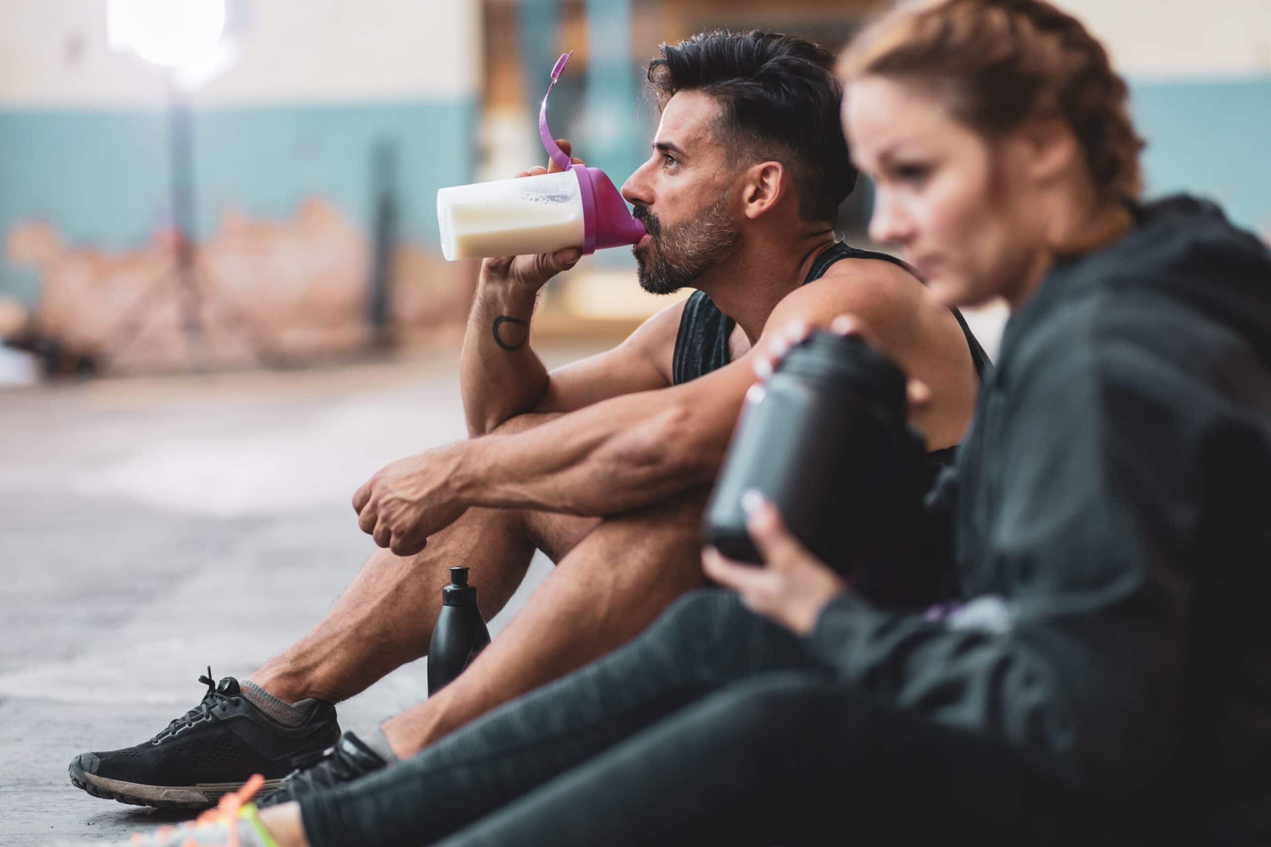 Красная после тренировки. Питание и тренировки. Спортсмен пьет. Спортивное питание для спортсменов. Мужчина пьет протеиновый коктейль.